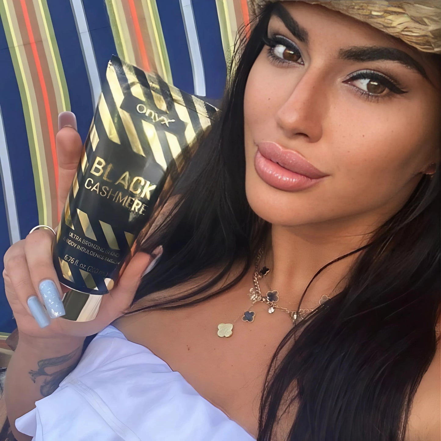 Mujer de cabello oscuro sostiene loción bronceadora frente a la cámara