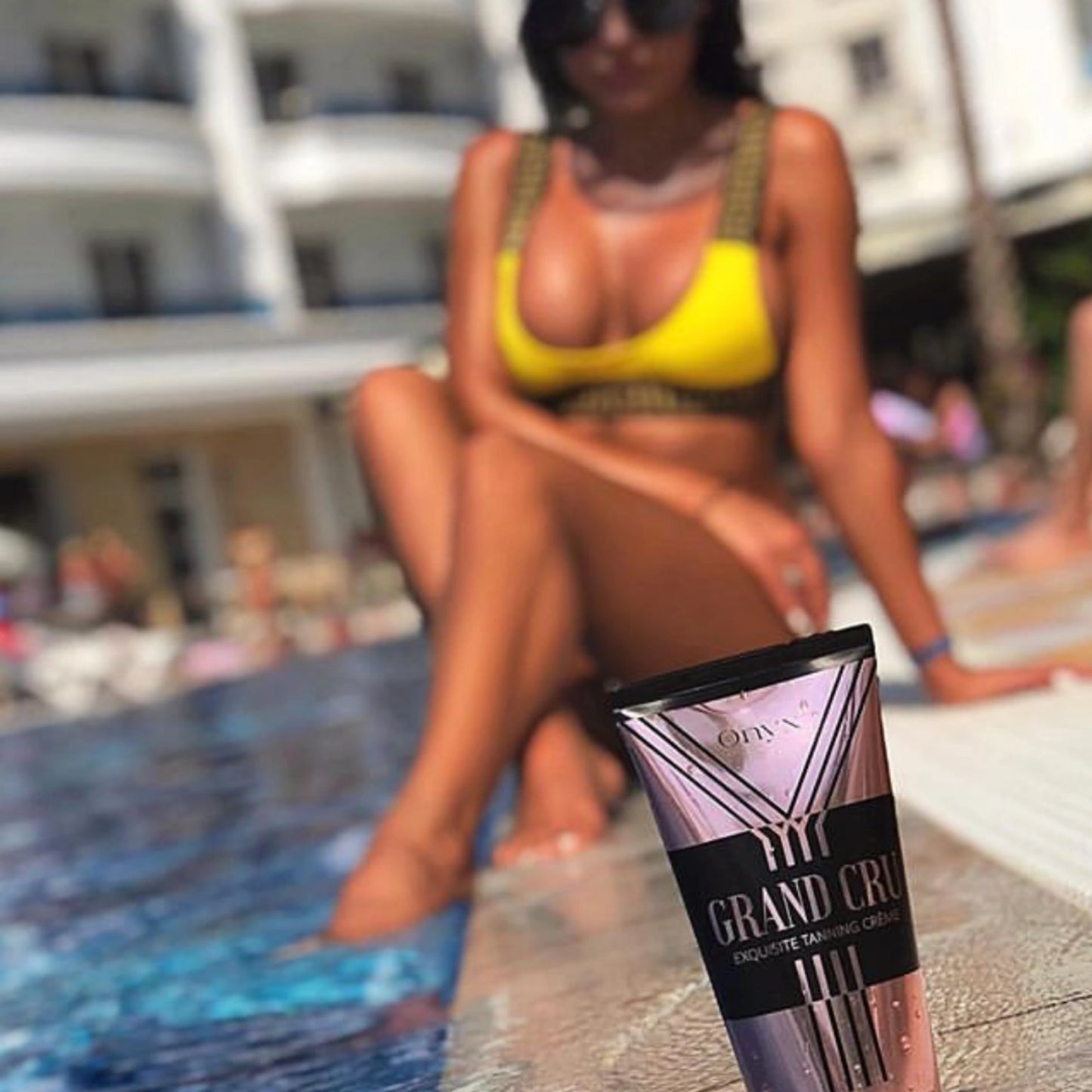 Loción Onyx Grand Cru frente a una mujer en la piscina – cuidado solar perfecto para un bronceado uniforme en la tumbona