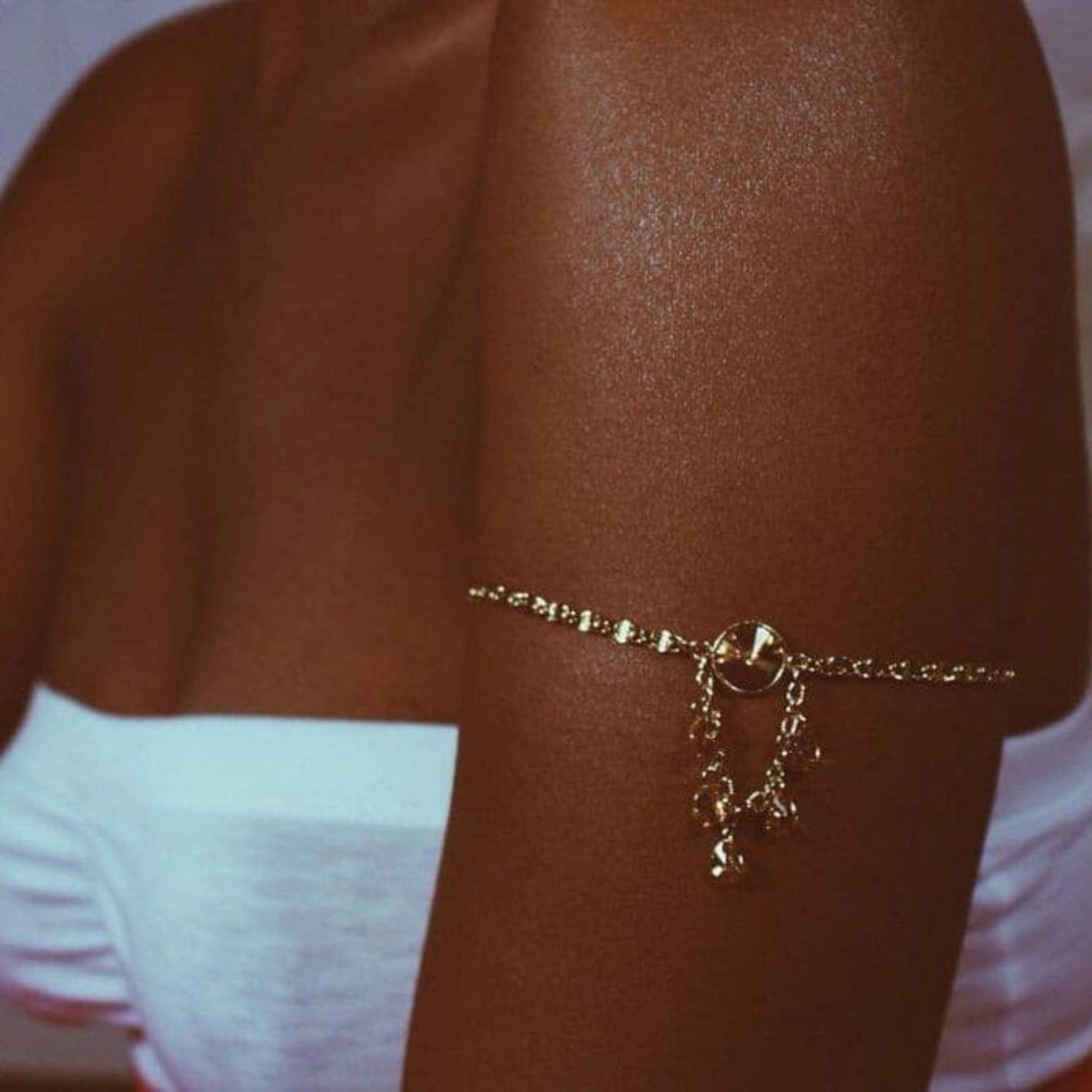 Primer plano de piel brillante en la parte superior del brazo tras la aplicación de la loción Onyx La Playa Glow