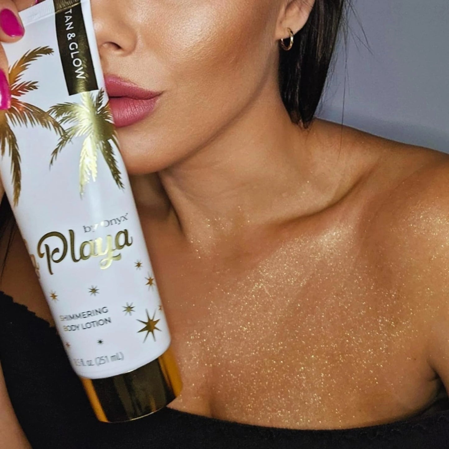 Mujer muestra escote con piel brillante tras la aplicación de Onyx La Playa Glow loción corporal