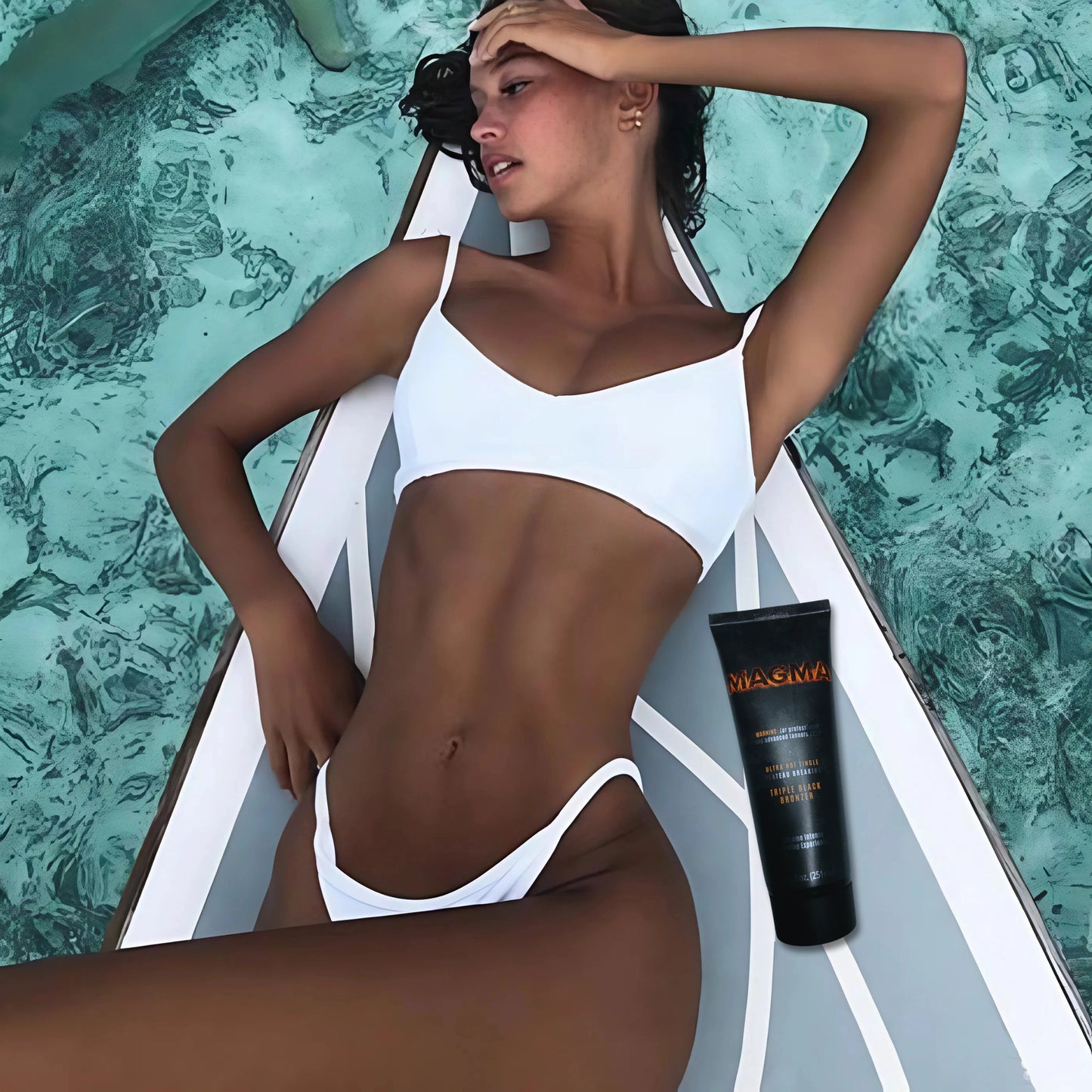 Mujer en bikini blanco recostada sobre una tabla de paddle en agua turquesa, con la loción Onyx Magma a su lado – bronceado perfecto en vacaciones de verano