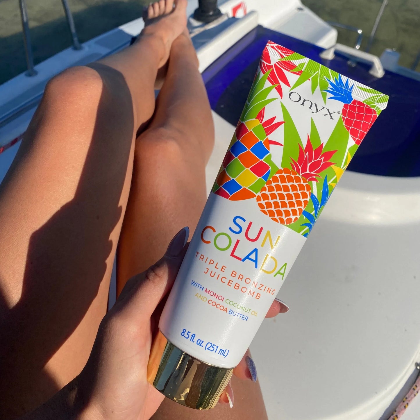 Suncolada loción bronceadora presentada al sol en un barco