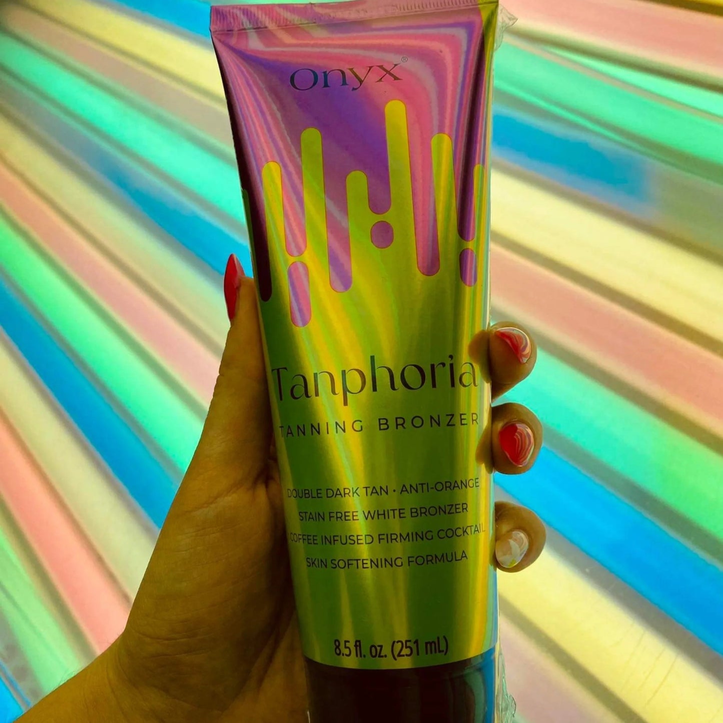 Tanphoria loción bronceadora sostenida frente a iluminación colorida de cama solar